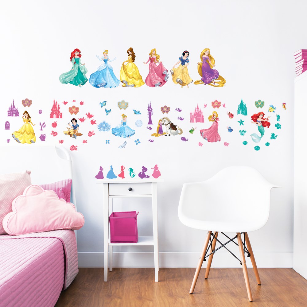 اتاق کودک دختری با تخت سفید و روتختی صورتی که روی دیوار آن استیکر شخصیت های کارتونی مانند پری دریایی و سفید برفی نصب شده است
